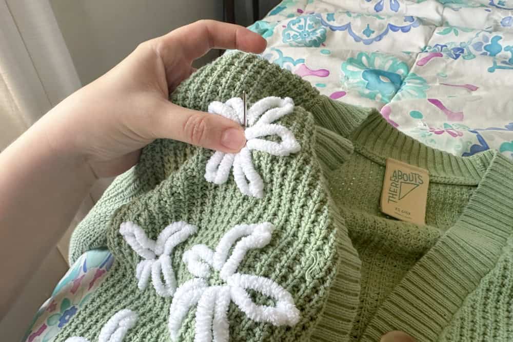 Needle being brought up on the edge of the flower's center.