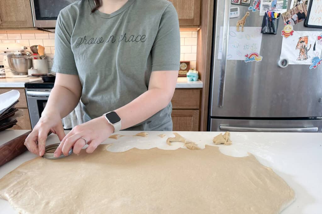 Marie is cutting out homemade doughnuts.