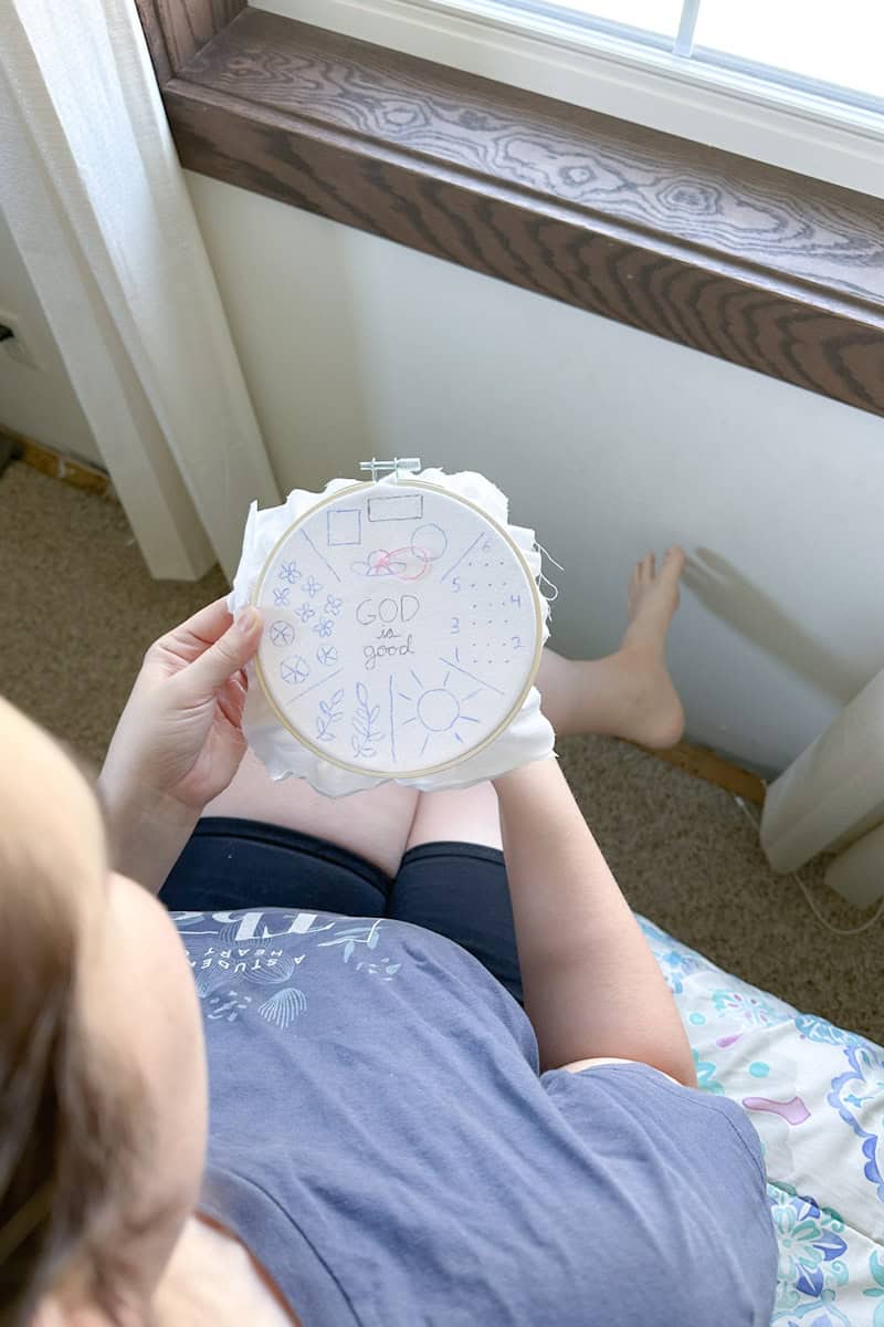 Marie stitching on a embroidery sampler.